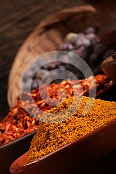 Three bowls of spices over wooden background.