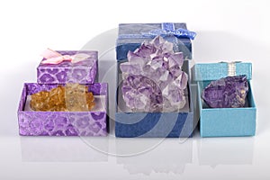 Three boxes with fluorite and amethyst stones and isolated on white