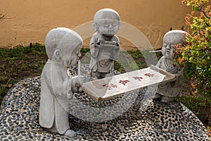 Three boy monk statues at Hsi Lai Buddhist Temple, California.