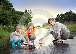 Three boy play in puddle