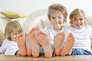 Three boys with bare feet on table