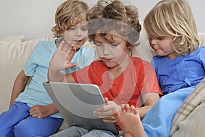 Three boys playing game on tablet