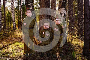 Three boys in uniform in the forest