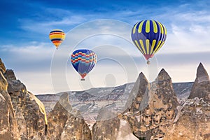 Three bright multi-colored hot air balloons flying in sky
