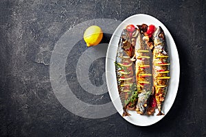 Three broiled mackerels on an oval dish