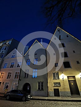 Three brothers building complex on Lai Street of Old Tallinn against the dark blue sky. Spring evening