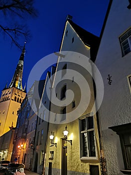 Three brothers building complex and the St. Olaf Baptist Church on one of the streets of Old Tallinn against the dark blue sky.