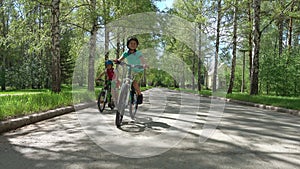 Three brothers riding bikes in sunny day.