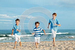 Three brothers are running on beach