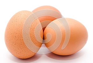 Three brown chicken eggs isolated on a white background