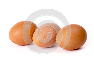 Three brown chicken eggs on a white