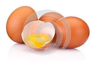 Three brown raw eggs and one is broken isolated white on white background