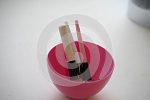 three brushes lie in a pink plate