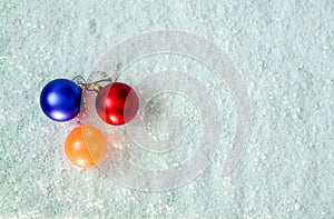 three bubbles,on white snow,top view,orange,blue,red,space for text,background for various christmas projects