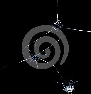 Three bullet hole in glass close up on black background