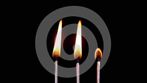 Three Burning Matches with a Bright Flame on a Black Background in Empty Space
