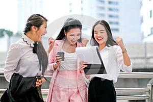 Three business Asian girls are acting as happy and exciting outside the office during day time