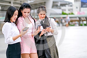 Three business Asian girls discuss together about their works outside the office during day time