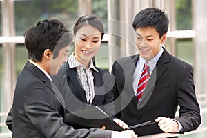 Three Business Colleagues Discussing Document