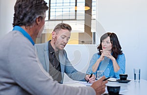 Three business colleagues having a meeting together in an office