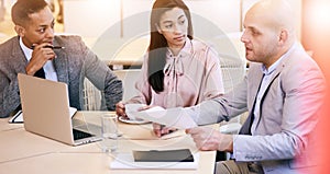 Three business executives communicating during meeting in conference room