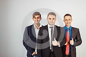 Three business men in suits standing like a team