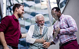 Three business men talking. They laugh