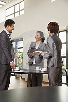 Three business people meeting in company cafeteria