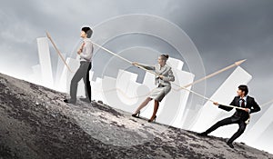 Three business people pulling rope