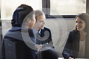 Three business people sitting and discussing at a business meeting