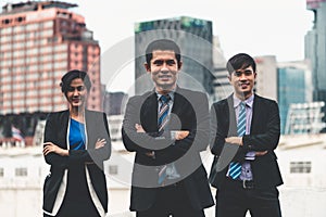 Three business people standing with arms crossed.