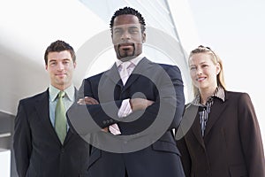 Three business people standing outdoors by buildin