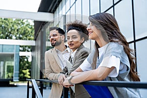 Three business people waiting in front of office building taking a break, before staff meeting. Lawyers and law students on