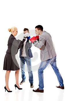 Three business people wearing boxing gloves start competition fight