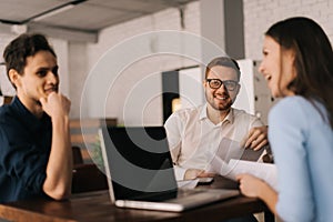 The three business people working at the table in the office