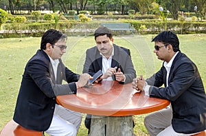 Three businessmen discussing business plan in park