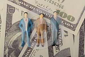 The three businessmen, a formidable trio, stood in solidarity against a money-themed backdrop, signifying their shared financial
