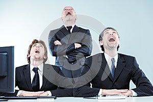 Three businessmen laughing or gawping