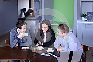Three businessmen, woman and men discussing robot with cup of te