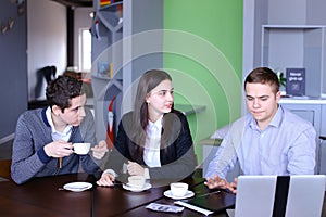 Three businessmen, woman and men discussing robot with cup of te