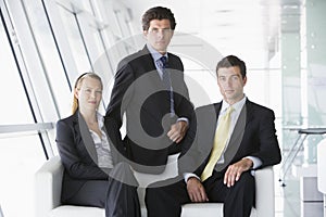 Three businesspeople sitting in office lobby