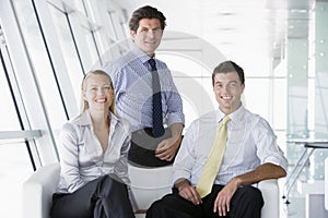 Three businesspeople sitting in office lobby