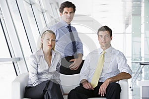 Three businesspeople sitting in office lobby