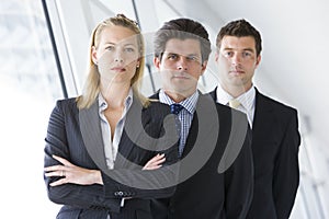 Three businesspeople standing in corridor