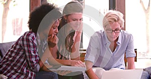 Three Businesswomen Having Informal Meeting In Office