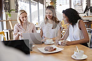 Three Businesswomen Having Meeting In Coffee Shop