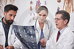 Three busy doctors discussing some medical records photo