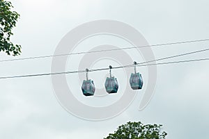 Three cable cars against cloudy sky in summer