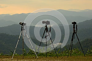 Three camera tripods photographer sunset.