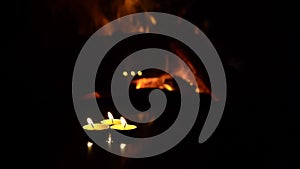 Three candles on a black background with a fireplace flame.